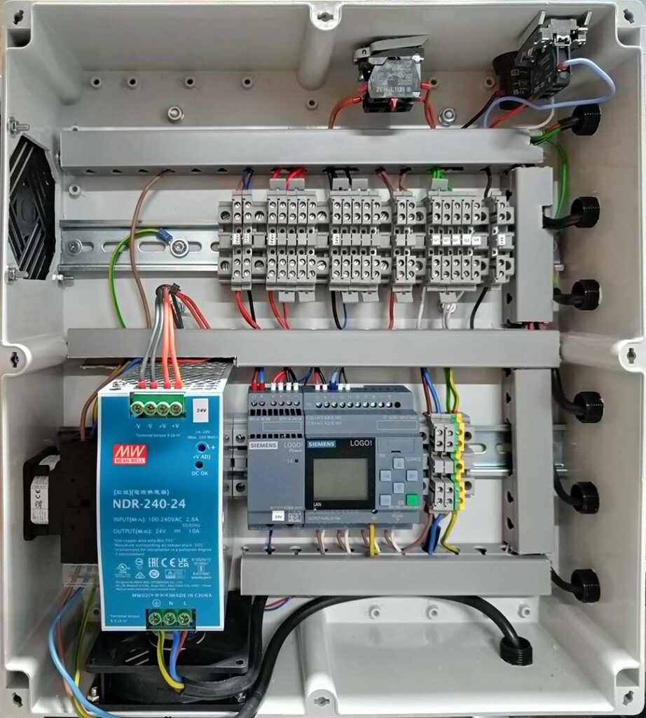 Foto van de industriële aansturingselektronica van een machine, weergegeven door robuuste schakelaars, bedieningspanelen en bekabeling, ontworpen voor duurzame en efficiënte machinebesturing.